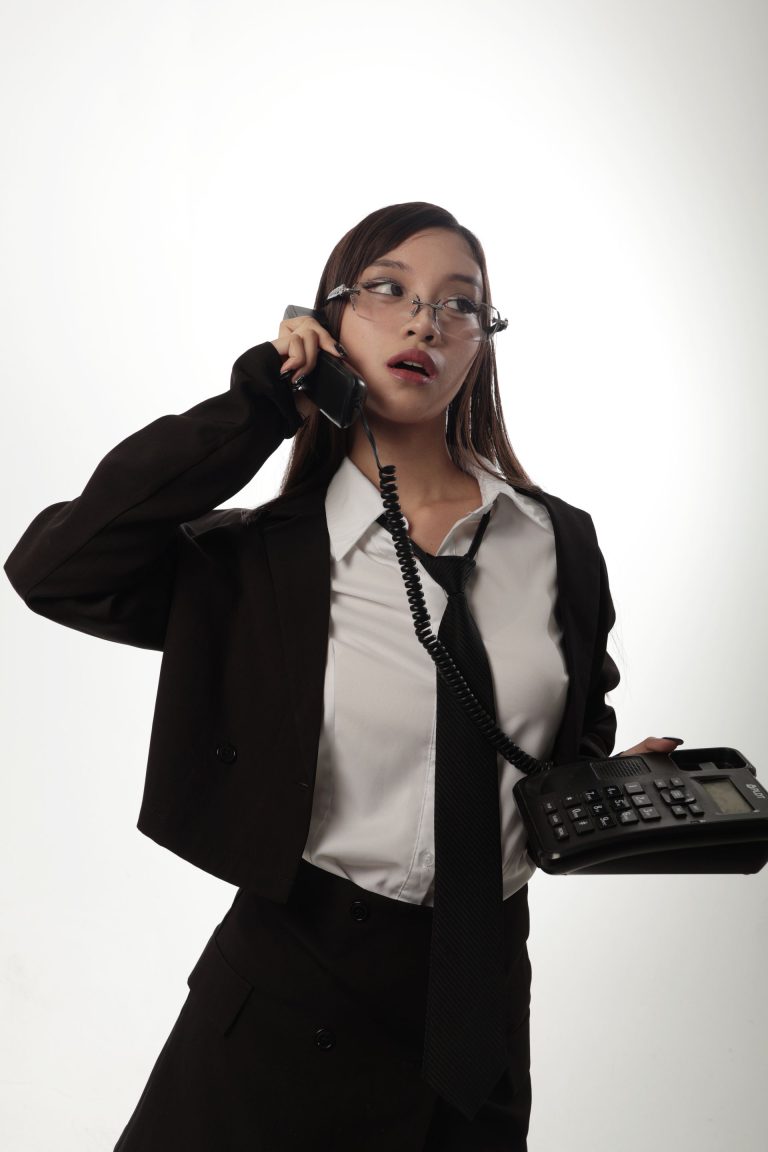 173 - Suit đen cầm điện thoại bàn chụp công sở